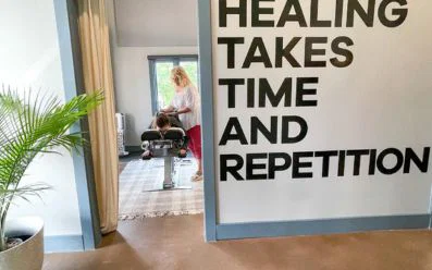 Chiropractor providing neck pain care for a woman during a family-friendly visit