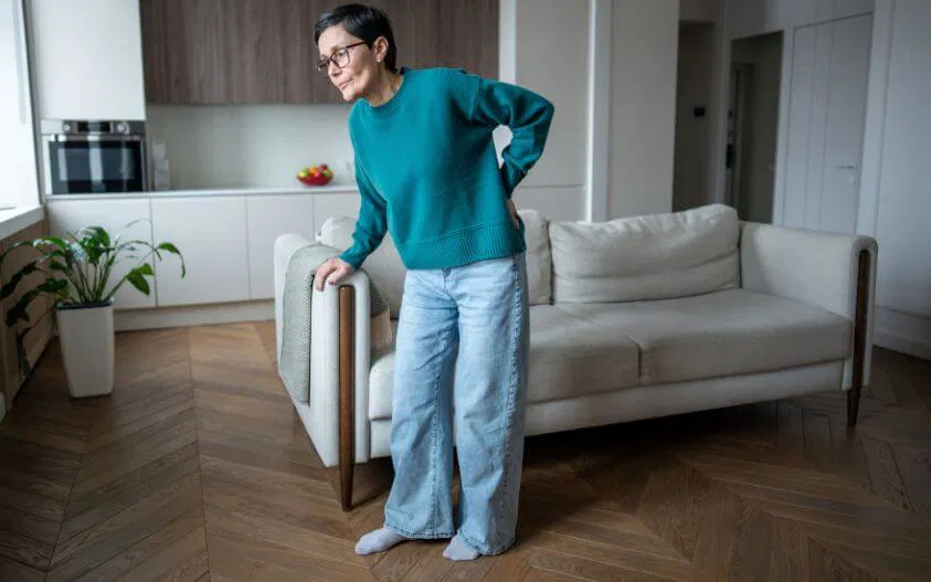 Woman holding lower back due to sciatica nerve pain